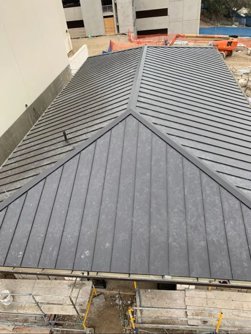 Commercial metal roof construction with crane equipment in North St. Paul